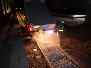 軌陸ダンプ軌間内砕石散布